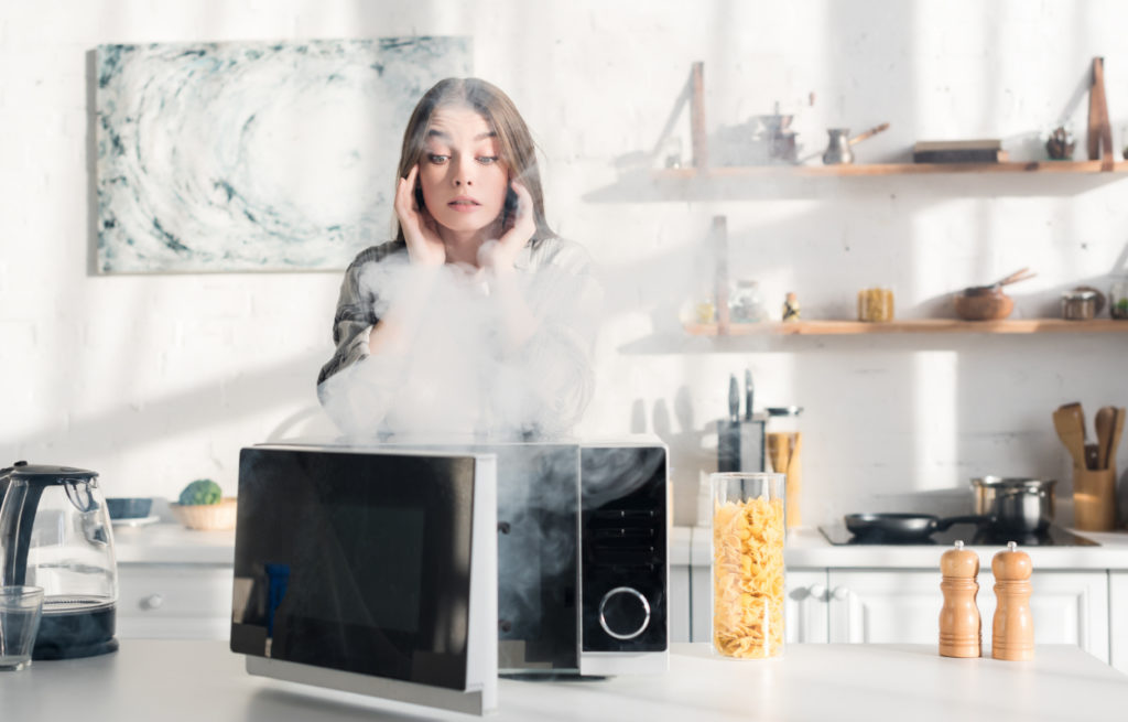 woman distressed by microwave smoking